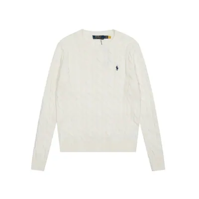 A cream cable knit jumper on a white background, long sleeved with a small embroidered motif on the chest